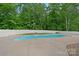 Backyard in-ground pool surrounded by a concrete deck and a white fence at 270 Worthington Dr, Mt Ulla, NC 28125