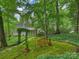 Beautiful backyard with lush moss, mature trees, and a charming bench at 3040 Valencia Ter, Charlotte, NC 28211