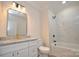 This bathroom features a granite-topped vanity, white cabinets, and a marble-tiled shower-over-tub with black fixtures at 307 N Catawba St, Lancaster, SC 29720