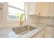 Close-up view of kitchen sink and granite countertops, enhanced with gold hardware and fixtures at 307 N Catawba St, Lancaster, SC 29720