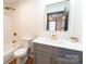 Bathroom featuring grey vanity with gold fixtures and mirror at 3150 Driftwood Dr # B, Charlotte, NC 28205