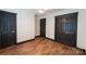 Bedroom with wood-look floors and three dark doors at 3150 Driftwood Dr # B, Charlotte, NC 28205