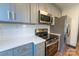 Bright kitchen features stainless steel appliances, quartz countertops, and updated gray cabinetry at 3150 Driftwood Dr # B, Charlotte, NC 28205