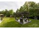 A backyard features a pergola with cushioned seating and lights at 3186 Helmsley Ct, Concord, NC 28027