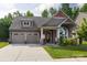 Charming home featuring a two-car garage, covered porch and a beautifully landscaped front yard at 3186 Helmsley Ct, Concord, NC 28027