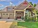 Charming home with a two-car garage, well-manicured lawn, and inviting front porch with double doors at 3186 Helmsley Ct, Concord, NC 28027