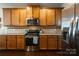 A well-equipped kitchen featuring stainless steel appliances, wooden cabinetry, and granite countertops at 3186 Helmsley Ct, Concord, NC 28027