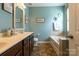Bathroom showcasing single sink vanity, large mirror, soaking tub and tiled shower at 3186 Helmsley Ct, Concord, NC 28027