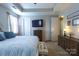Bright and airy bedroom featuring neutral tones, a TV, and easy access to the ensuite bathroom at 3186 Helmsley Ct, Concord, NC 28027
