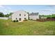View of the home's spacious backyard, with lawn, small patio, and privacy fence at 3512 Gibbon Terrace Ct, Charlotte, NC 28269