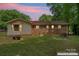 Exterior view of a home, showcasing the brick siding and a spacious backyard with mature trees at 393 Carson Dr, Gastonia, NC 28052