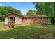 Exterior view of a home, showcasing the brick siding and a spacious backyard with mature trees at 393 Carson Dr, Gastonia, NC 28052