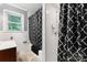 Bathroom featuring a shower with a black-and-white patterned curtain, and a window providing natural light at 393 Carson Dr, Gastonia, NC 28052