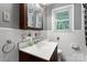 Well-lit bathroom featuring a white vanity, mirrored cabinet, and a window offering natural light at 393 Carson Dr, Gastonia, NC 28052