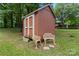 Outdoor shed with double doors and ornamental chairs adding charm to the yard at 393 Carson Dr, Gastonia, NC 28052