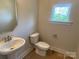 Cozy half-bathroom featuring a pedestal sink, toilet, and window at 412 Nathaniel Way # Brx0052, Charlotte, NC 28213