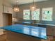 Well-lit kitchen with gray cabinetry, island, and stainless steel microwave at 412 Nathaniel Way # Brx0052, Charlotte, NC 28213