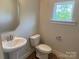 Powder room features pedestal sink, toilet and window providing ample natural light at 416 Nathaniel Way # Brx0051, Charlotte, NC 28213