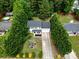 An aerial view showcasing a home with mature trees, well-maintained lawn, long driveway, and neighborhood at 4332 Bathurst Dr, Charlotte, NC 28227