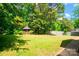 Large backyard with a lush lawn, mature trees, and a charming gazebo at 4332 Bathurst Dr, Charlotte, NC 28227