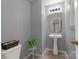 Powder room featuring a pedestal sink, and a toilet with a decorative plant and a framed mirror at 4332 Bathurst Dr, Charlotte, NC 28227