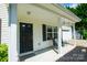 A cozy front porch with black door, classic white trim, and a seating area at 4332 Bathurst Dr, Charlotte, NC 28227