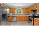 A functional kitchen featuring stainless steel appliances, wood cabinets, and laminate flooring at 4332 Bathurst Dr, Charlotte, NC 28227