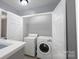 A laundry room with modern washer, dryer, folding counter and storage shelves at 4332 Bathurst Dr, Charlotte, NC 28227