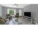A modern living room is designed with neutral tones, wood flooring and a large window at 4332 Bathurst Dr, Charlotte, NC 28227