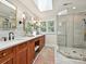 Bathroom featuring a double vanity, skylight, and glass-enclosed shower at 4701 Pineland Pl, Charlotte, NC 28277