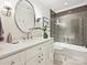 Bathroom featuring a modern vanity, round mirror, and tiled shower/tub at 4701 Pineland Pl, Charlotte, NC 28277