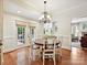 Cozy dining room featuring hardwood floors, elegant chandelier, and access to the outdoor deck at 4701 Pineland Pl, Charlotte, NC 28277