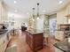 Bright kitchen with hardwood floors, a center island with bar seating, and views of living area at 4701 Pineland Pl, Charlotte, NC 28277
