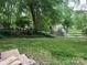 Spacious backyard area with mature trees, offering a serene and private outdoor setting at 4905 Montibello Dr, Charlotte, NC 28226