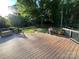 Large wooden deck with railings overlooking a backyard with mature trees and landscaping at 4905 Montibello Dr, Charlotte, NC 28226