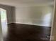 Well-lit living room presents classic hardwood flooring, wainscoting, and view to another room at 4905 Montibello Dr, Charlotte, NC 28226