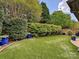 Well manicured backyard features artificial turf, brick accent wall, mature landscaping, and privacy at 5603 Ballinard Ln, Charlotte, NC 28277