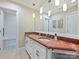 A bathroom features a double vanity with a coral countertop, framed mirror and tile flooring at 5603 Ballinard Ln, Charlotte, NC 28277