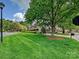 A lush green lawn features mature trees and manicured landscaping and a view of the front of the home at 5603 Ballinard Ln, Charlotte, NC 28277