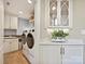 Bright laundry room with washer, dryer, cabinets, and countertop with stylish backsplash at 5603 Ballinard Ln, Charlotte, NC 28277