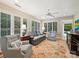 Bright living room with large windows, shutters, ceiling fan and stylish patterned chairs and rug at 5603 Ballinard Ln, Charlotte, NC 28277