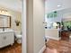 Hallway view of powder room with a white vanity and hardwood floors at 5603 Ballinard Ln, Charlotte, NC 28277