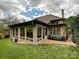 A covered patio with brick flooring is surrounded by lush green lawn and landscaping at 5603 Ballinard Ln, Charlotte, NC 28277