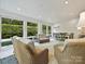 Beautiful sunroom with white plank ceiling, ample windows overlooking green exterior and seating area at 5603 Ballinard Ln, Charlotte, NC 28277