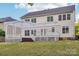 Backyard with a deck, white pergola, and large windows offering ample natural light into the house at 5745 Snapdragon Ln, Huntersville, NC 28078