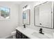 Bright bathroom featuring dual sinks with modern fixtures and lighting, and a window providing natural light at 5745 Snapdragon Ln, Huntersville, NC 28078