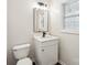 Small bathroom featuring a modern vanity, toilet, and a window for natural light at 5745 Snapdragon Ln, Huntersville, NC 28078