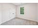 Neutral bedroom featuring new carpet, base trim and a window providing natural light at 5745 Snapdragon Ln, Huntersville, NC 28078
