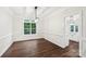 Formal dining room with dark hardwood floors and modern chandelier, open to a kitchen area at 5745 Snapdragon Ln, Huntersville, NC 28078