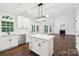 Modern kitchen with white cabinets, stainless steel appliances, island, and view into a sunlit living area at 5745 Snapdragon Ln, Huntersville, NC 28078